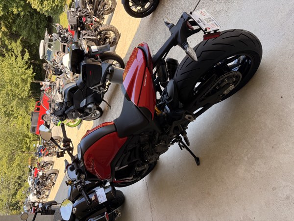 Rear three-quarter of the 2026 Ducati Monster+ with showroom tag