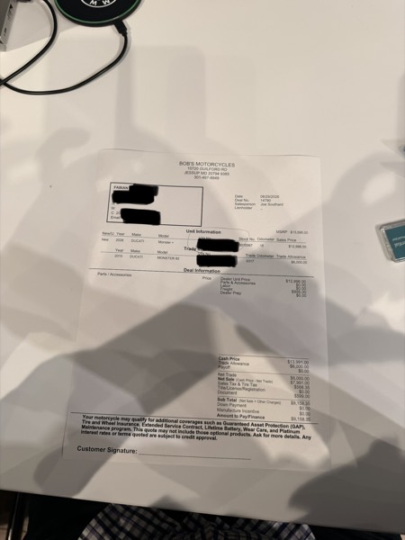 Redacted Bob's Motorcycles deal sheet showing cash price, trade allowance, net sale, sales and tire tax, document fee, and amount to pay